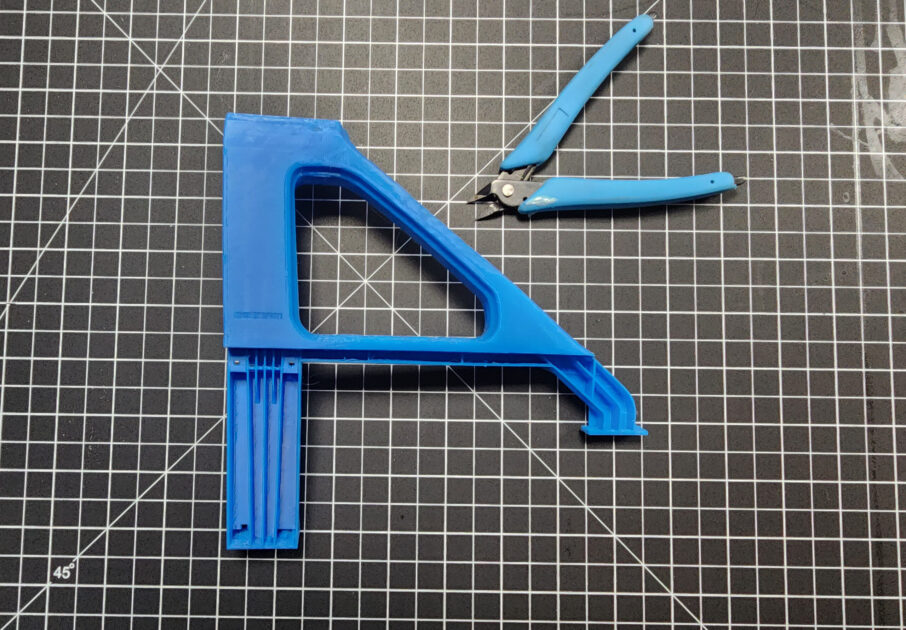 3D printed object with blue wire cutters.